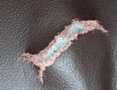 Fleischspaltleder sind gegenüber Narbenspaltledern deutlich weniger reißfest, da die Fasern weniger stark miteinander vernetzt sind. Das Bild zeigt das charakteristische Ausfransen solcher Leder am Rand von Rissen.